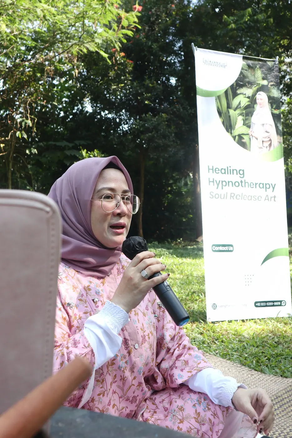 Pembicara berbagi di depan banner Healing